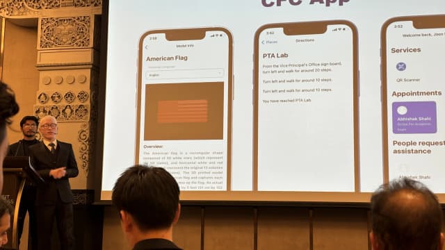 Project lead Joon Shakya is giving presentation. On his left Project Secretary Karmendra Shrestha is standing and on the background a picture of CFC app is being displayed.