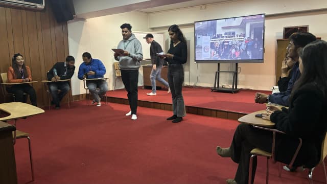 The MCs of the event Sangam Khadka and Sanskriti Pokharel are hosting the event. Other project members can be seen on their left, back and right being seated.