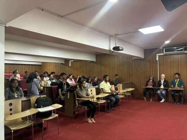 Around 25 participants are meditating listening to the sound of Singing bowls.