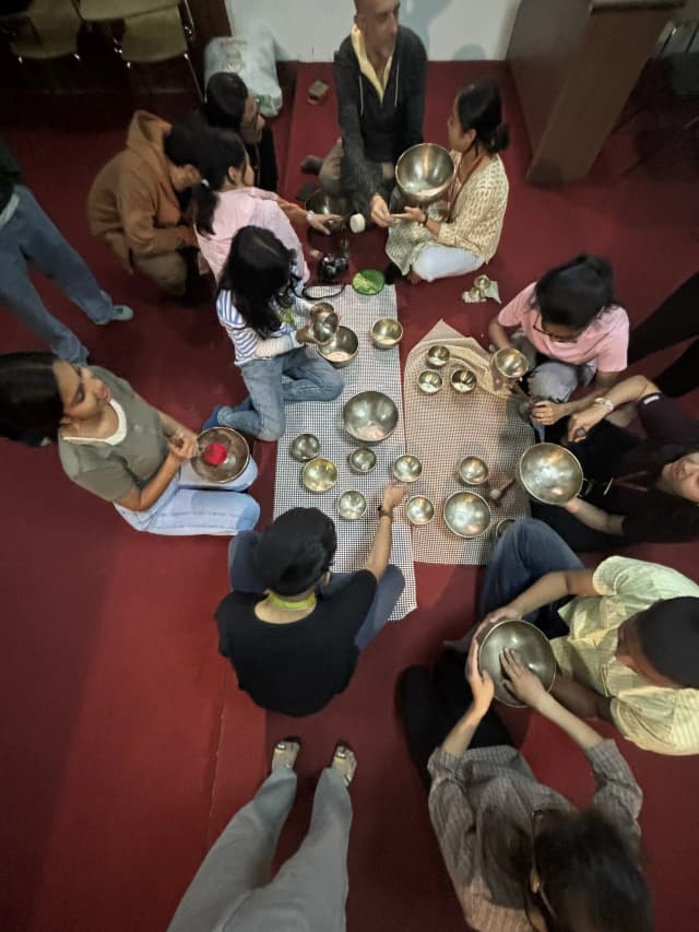 Participants are observing and learning to play singing bowls.