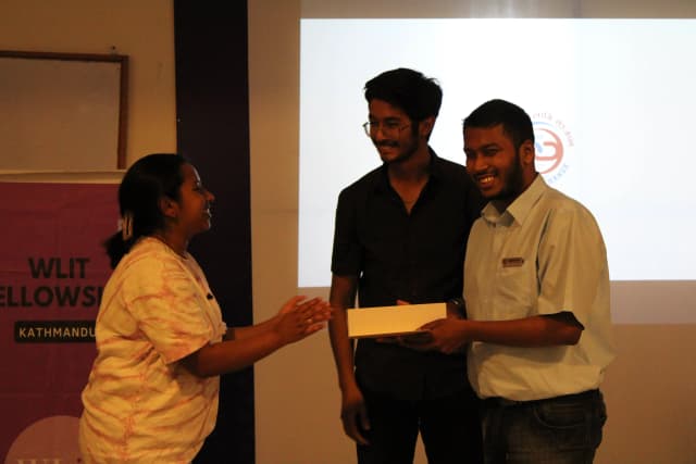 Executive Director of Women Leaders in Technology handing over a token of love and greeting card to the Founder & President of Chain For Change Abhishek Shahi. Even Project Secretary Karmendra Shrestha is also observed.