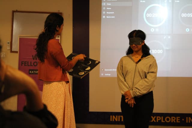 A participant is explaining another blindfolded participant about the 3D model of Phases of Moon.