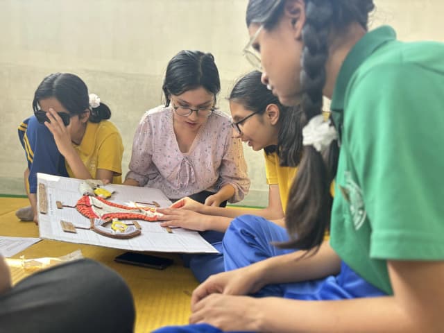 A group of female students with visual disabilities in the workshop are touching the accessible 3D model of internal female reproductive system and our project member Sanskriti Ghimire is supporting them.