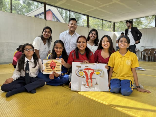 A group picture of female students with visual disabilities and project members who are holding the accessible 3D models of inner and external female reproductive system.