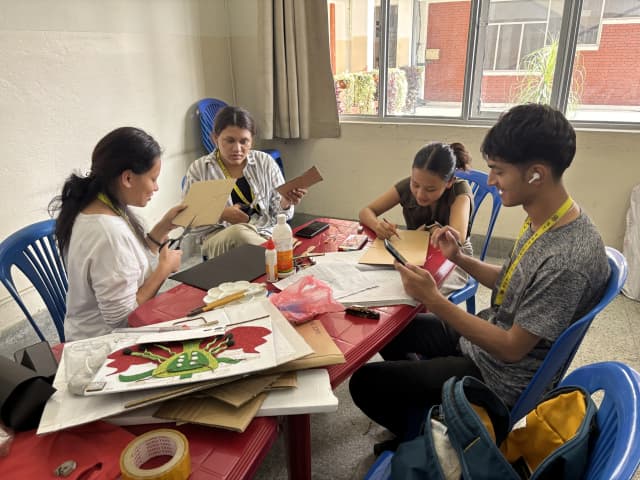 4 of the project members (2024/25) from non-computer team are developing a 3D model using locally available resources. Some of them are cutting the cardboard and some of them are writing.