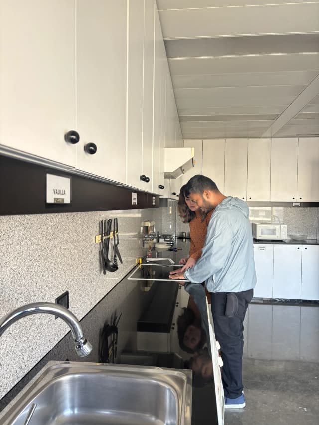 Our Founder Abhishek Shahi is touching the induction stove kept at the ONCE and Belén – the Técnico Rehabilitación is supporting him.