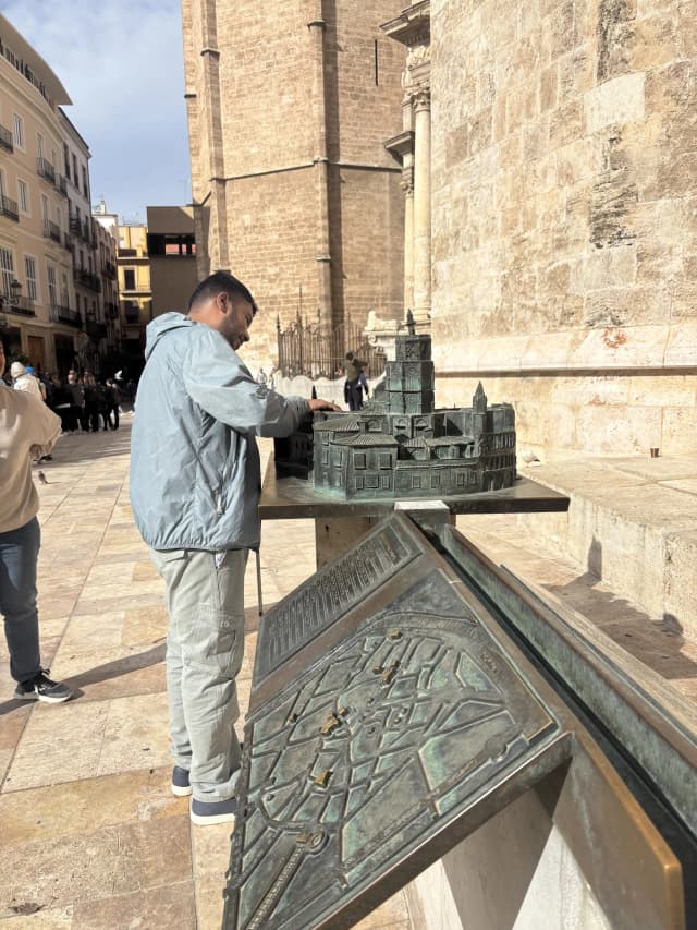 Our Founder, Abhishek Shahi is touching the Maqueta of The Catedral de Valencia made from metal in the heritage site.