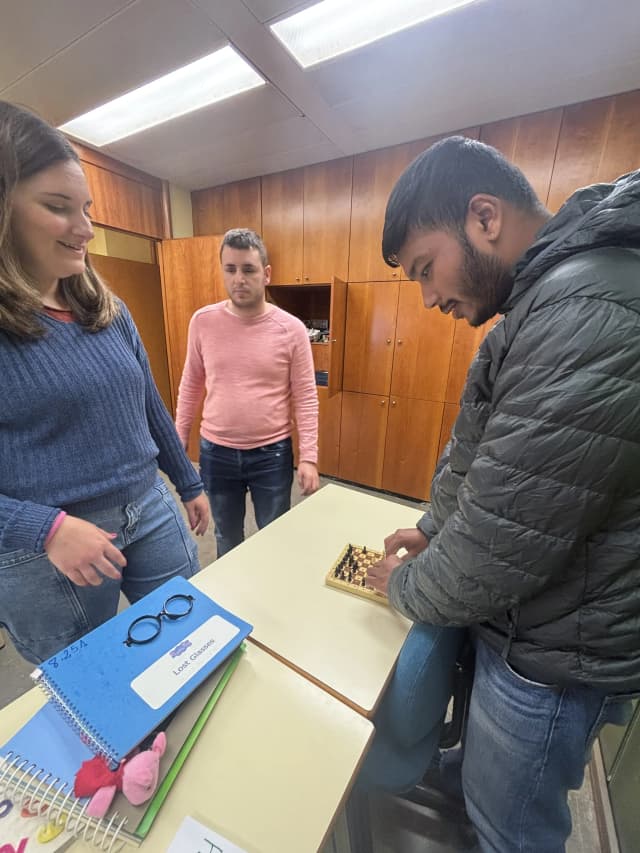 Our founder Abhishek Shahi is touching the chess board game made for the persons with visual disabilities. In the background, Belén and one of the braille teachers is observed.