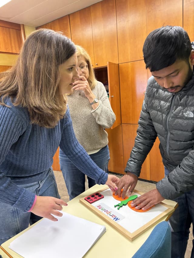 Belén is supporting our Founder Abhishek Shahi to touch butterfly braille learning kit. In the background, one of the math teachers is also observed.