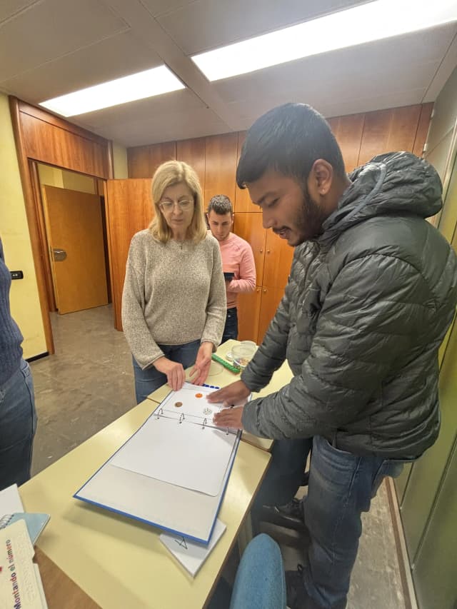 One of the Math teachers is supporting our Founder Abhishek Shahi to use the counting braille books made for children with visual disabilities. In the background, one of the braille teachers is also observed.