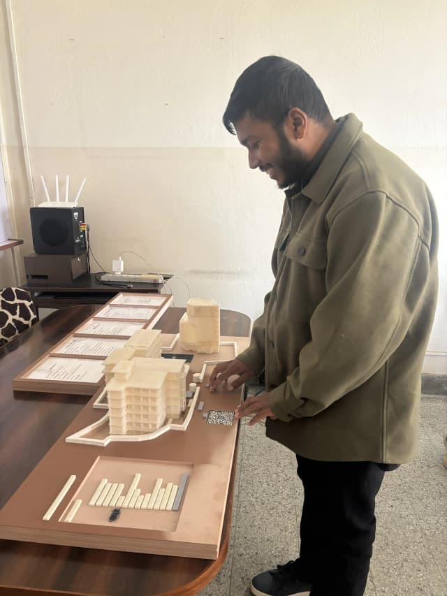 A picture of our Founder Abhishek Shahi touching the Maqueta of St. Xavier’s College.