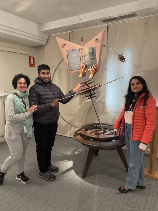 Our Founders Abhishek Shahi and Deepika Shahi along with Fanny Collado Infront of a 3D model of a rotating globe with a textbook placed in the center which is called 'El Mundo a Tu Alcance' (The World at Your Reach) created by José Luis Gómez.