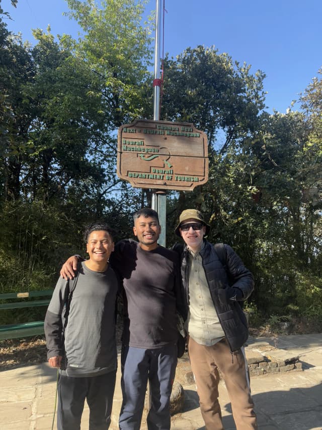 A group picture of 3 male project members taken Infront of the map.